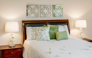 Master bedroom-close up details. Master bedroom-close up details of white bed spread with green leafy theme and leather covered headboard.