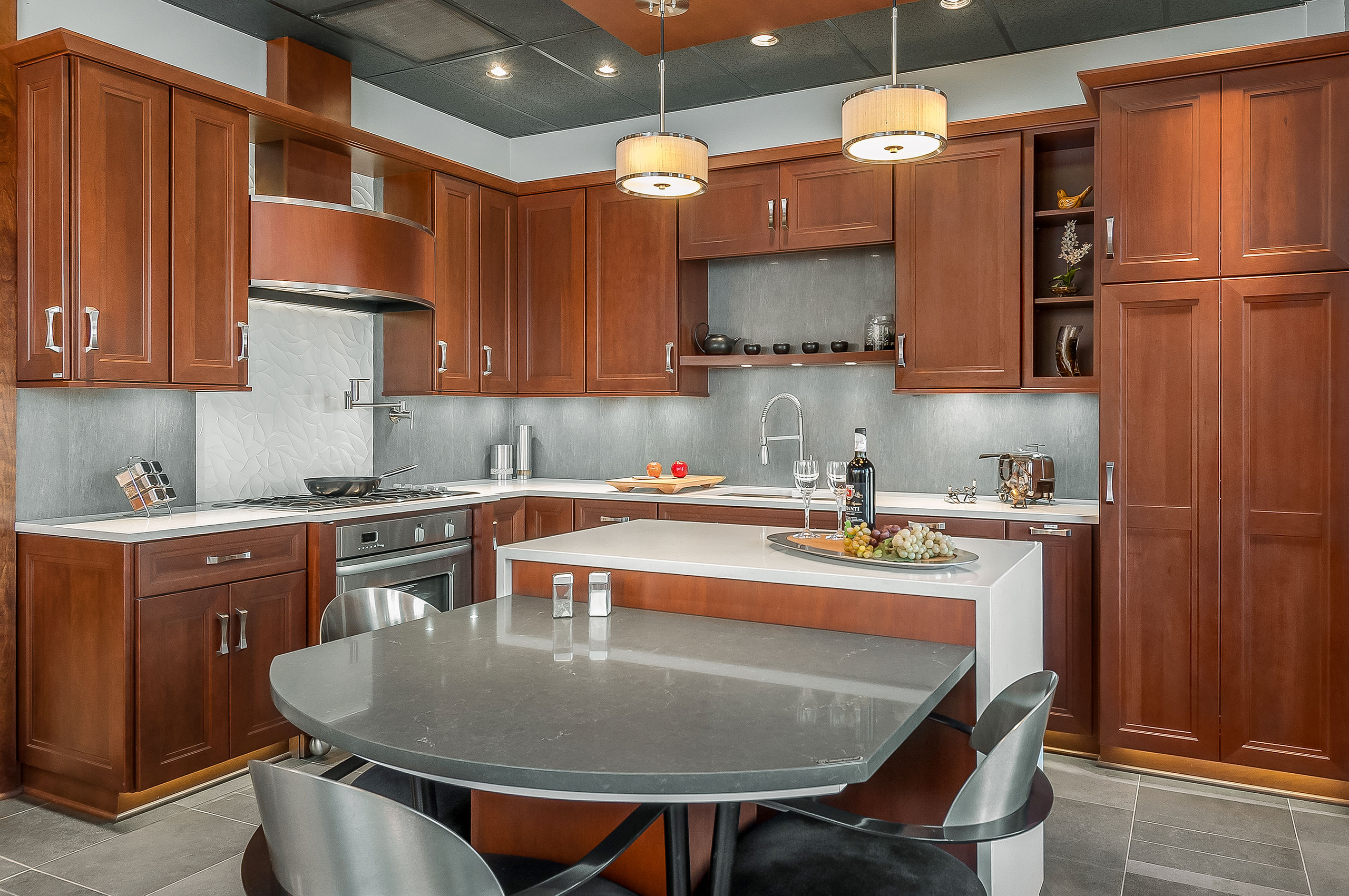 Upscale cherry and gray kitchen with stainless appliances.